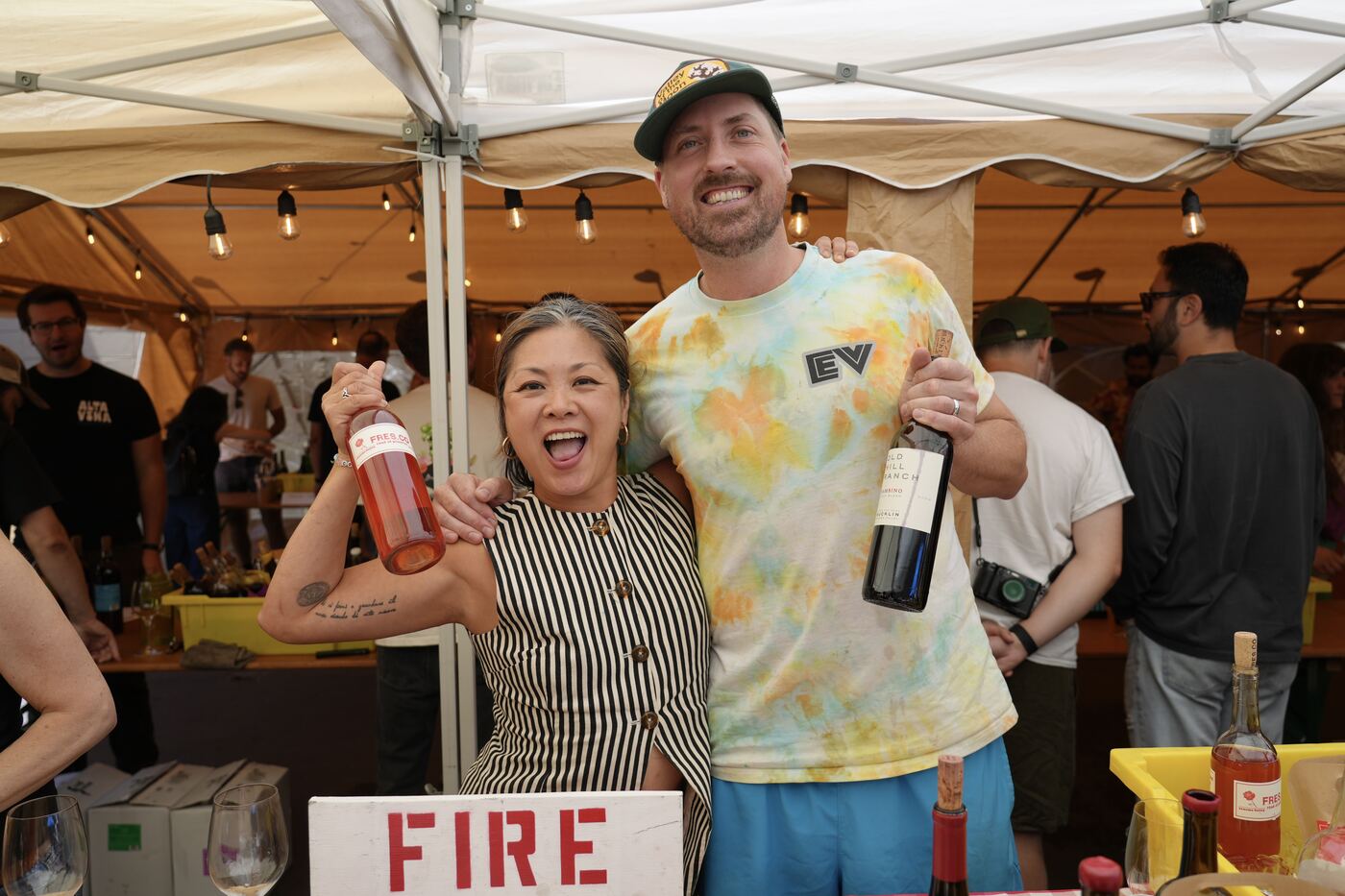 Two winemakers laughing with bottles raised