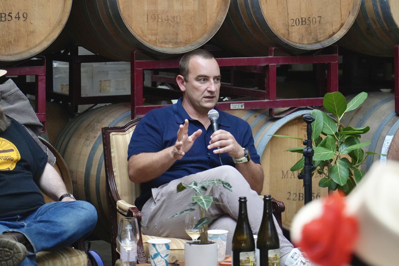 A panelist speaking among the barrels