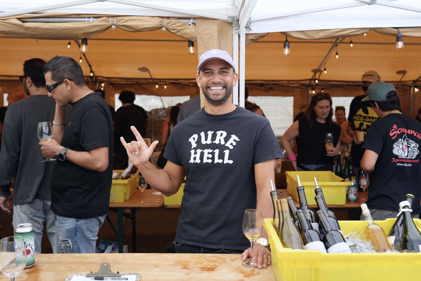 A winemaker in a Pure Hell t-shirt behind the pouring table
