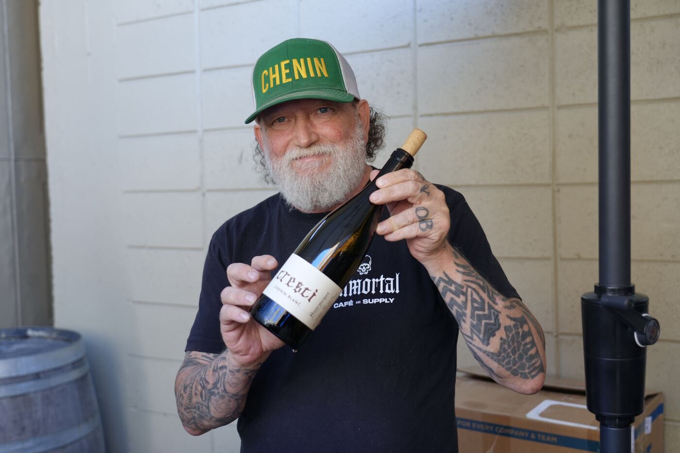 Winemaker in a Chenin cap holding a bottle